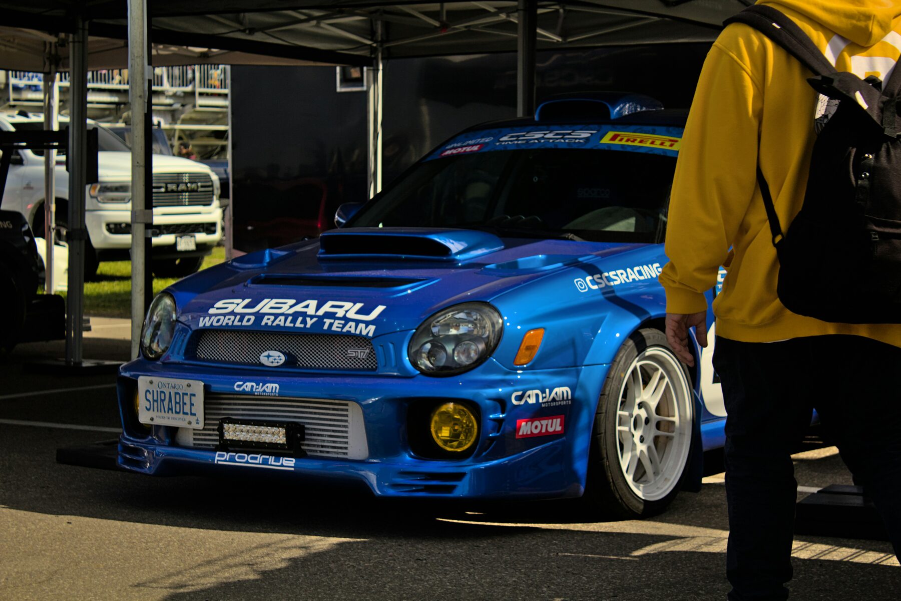 Blue Subaru WRX STI rally car at a motorsport event