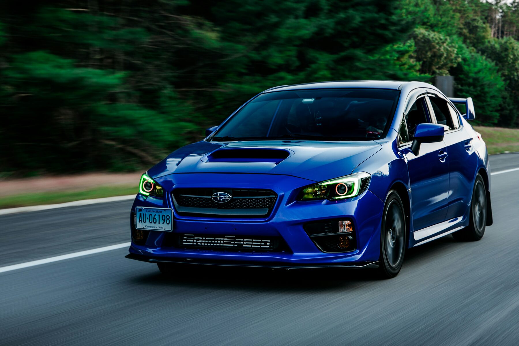 Blue Subaru WRX driving on a road