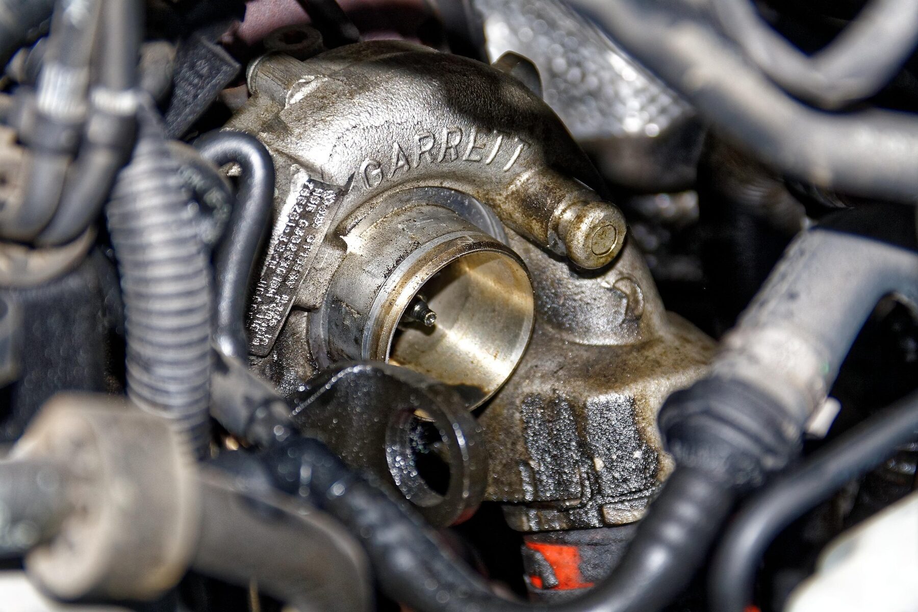 Close-up of a turbocharger installed in an engine bay