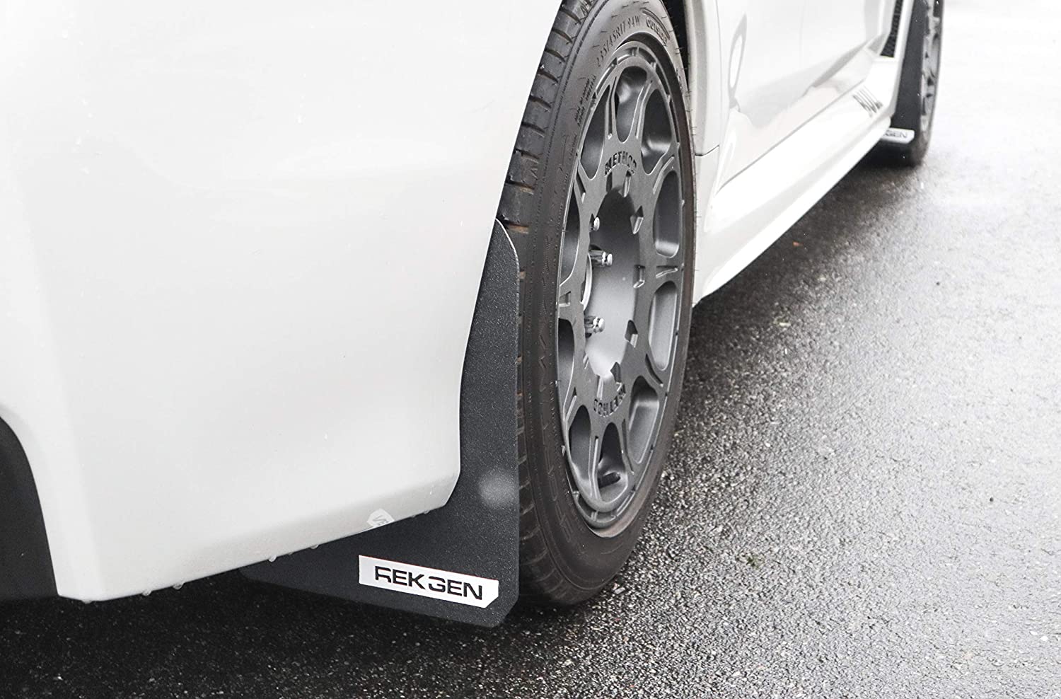 REK GEN mud flaps with a white logo on a white Subaru WRX